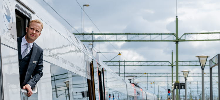 En lokförare som tittar ut genom sitt fönster på tåget.